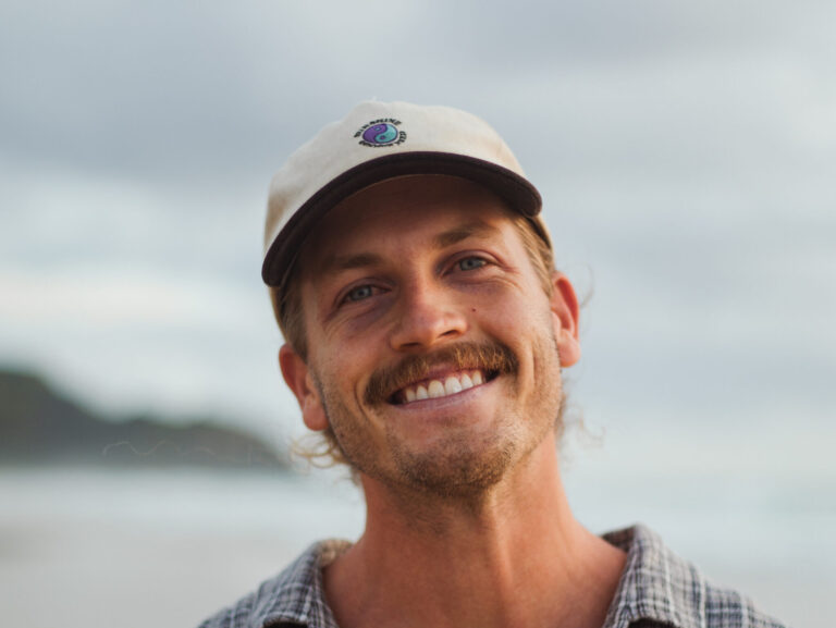 David McCredie performing at Surfana Festival, bringing warm indie-folk vibes and a radiant smile.